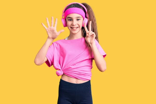 Linda Niña Hispana Vistiendo Ropa Gimnasio Usando Auriculares Que Muestran —  Fotos de Stock