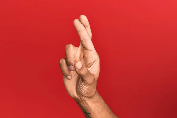 Mão Homem Hispânico Sobre Vermelho Fundo Isolado Gesticulando Dedos Cruzados — Fotografia de Stock