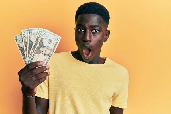 Νεαρός Αφροαμερικάνος Που Κρατάει Δολάρια Φοβισμένος Και Έκπληκτος Ανοιχτό Στόμα — Φωτογραφία Αρχείου
