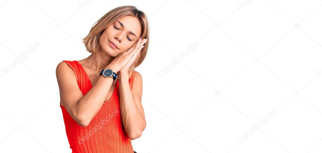 Beautiful caucasian woman wearing casual clothes sleeping tired dreaming and posing with hands together while smiling with closed eyes. 