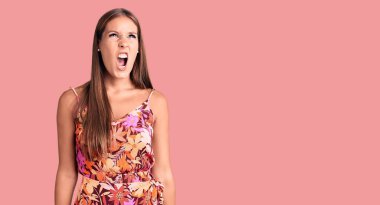 Genç ve güzel İspanyol bir kadın, gündelik giysiler giyiyor kızgın ve kızgın bağırıyor, sinirden köpürüyor, öfkeyle bağırıyor. öfke ve agresif konsept. 