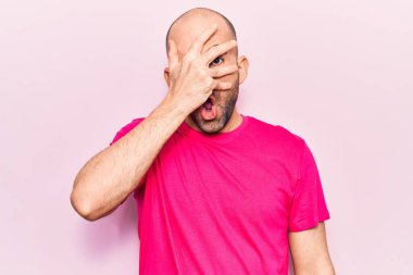 Genç, yakışıklı, kel bir adam. Günlük tişört giyiyor. Şoka girip yüzünü ve gözlerini eliyle kapatıyor. 