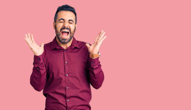 Gündelik kıyafetler giyen genç İspanyol adam başarı için deli ve çılgınlığı kutluyor kollarını kaldırmış ve gözlerini kapatmış heyecanla bağırıyor. Kazanan konsept 