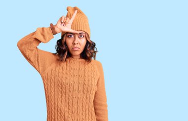 Genç, güzel, melez bir kadın yün kazak ve kış şapkası giyiyor. Alnında parmakları olan insanlarla dalga geçiyor. Ezik hareketler yapıyor, alay ediyor.. 