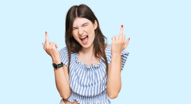 Young beautiful caucasian girl wearing casual clothes showing middle finger doing fuck you bad expression, provocation and rude attitude. screaming excited 