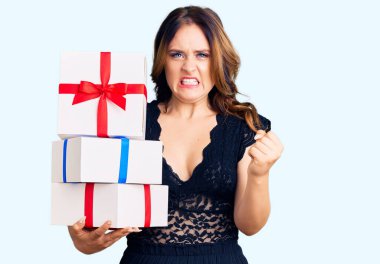 Elinde hediyeler tutan güzel beyaz bir kadın öfkeyle bağırıyor, öfkeyle bağırıyor ve el kaldırıyor. 