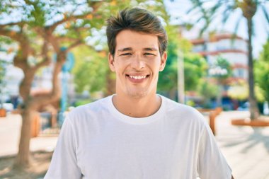 Genç beyaz adam gülümsüyor.