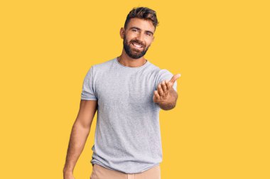 Gündelik kıyafetler giyen, neşeli gülümseyen, yardım eli uzatan ve kabul gören genç İspanyol bir adam.. 