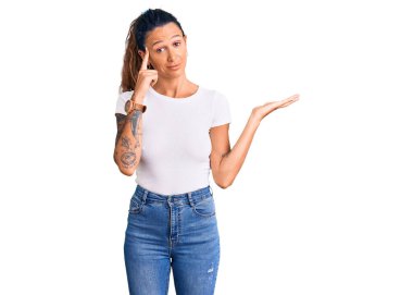 Gündelik beyaz tişörtlü, İspanyol bir kadın açık avuç içiyle fotokopi alanı gösterip alnını işaret etmekten rahatsız oluyor. Bunu bir düşün.. 