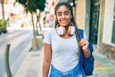 Genç Afrikalı Amerikalı öğrenci kampüste mutlu gülümsüyor.