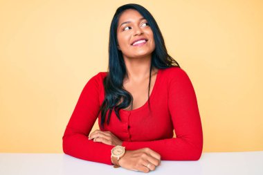 Güzel, uzun saçlı, günlük kıyafetler giyen, yan tarafa bakan, rahat bir görünüm takınan, kendine güvenen ve gülümseyen bir kadın.. 