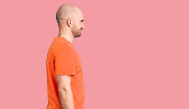 Genç yakışıklı adam sıradan bir tişört giyiyor. Taraf arıyor, rahat bir poz veriyor. Kendine güvenen bir gülümsemesi var.. 