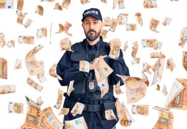 Polis üniforması giyen genç yakışıklı adam saati, sabırsızlığı ve rahat bir ifadeyle kameraya bakıyor.