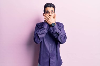 Sıradan gömlek giyen sakallı genç yakışıklı adam yanlışlıkla elleriyle ağzını kapatırken şok oldu. gizli kavram. 