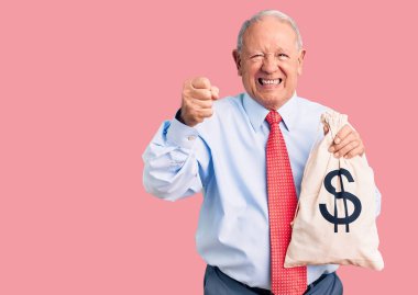 Yakışıklı, beyaz saçlı, şık kıyafetler giyen, para çantası tutan sinirli ve sinirli bir adam. Öfkeyle bağırıyor, öfkeyle bağırıyor ve el kaldırıyor. 