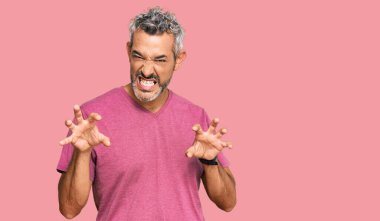 Orta yaşlı, gri saçlı, günlük kıyafetler giyen, komik gülümseyen, pençelerini kedi gibi gösteren, saldırgan ve seksi bir ifade takınan bir adam. 