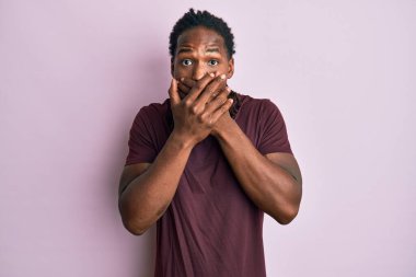 Sıradan kıyafetler giyen Afro-Amerikalı bir adam ağzını yanlışlıkla elleriyle kapatarak şok geçirdi. gizli kavram. 