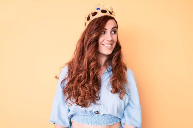 Prenses tacı takan genç ve güzel bir kadın. Taraf arıyor, rahat bir poz veriyor, doğal bir yüz ve kendine güvenen bir gülümseme.. 