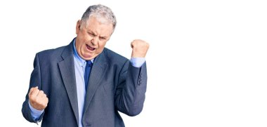 İş ceketi giyen yaşlı gri saçlı adam kolları havada ve gözleri kapalı bir şekilde başarıyı kutluyor ve şaşırıyor. Kazanan konsept. 