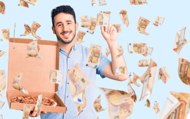 Elinde pizza kutusu olan genç İspanyol bir adam bir fikirle ya da soru sorarak şaşırdı ve mutlu bir yüzle işaret etti.