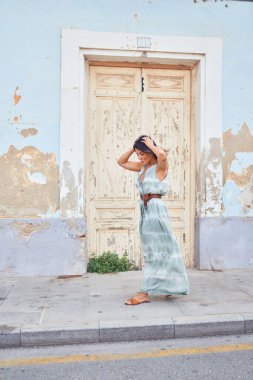 Güzel, genç bir kadın, şık kıyafetler giyip sokakta yürüyor.