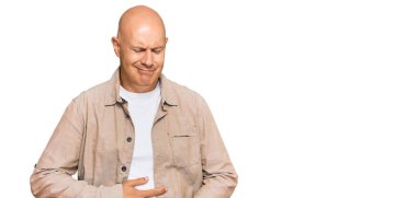 Orta yaşlı kel bir adam elleri karnında günlük kıyafetler giyiyor çünkü hazımsızlık, acı verici bir hastalık kendini iyi hissetmiyor. Ağrı kavramı. 