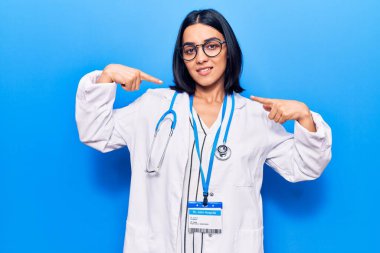 Doktor steteskobu ve kimlik kartı takan genç, güzel bir Latin kadın. Kendine güvenen, gülümseyen, kendini gururlu ve mutlu gösteren biri.. 