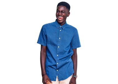 Genç Afro-Amerikalı sıradan kıyafetler giymiş, kameraya seksi bir ifadeyle bakıyor, neşeli ve mutlu bir yüzle.. 