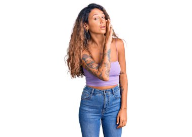 Dövmeli genç İspanyol kadın. Günlük giysiler giyiyor. Ağzı ağızda gizli dedikodular anlatıyor. 