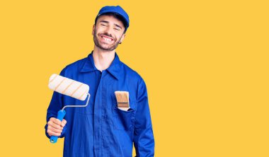 İspanyol ressam üniforması giyen genç adam elinde silindir tutuyordu. Pozitif ve mutlu görünüyordu. Kendine güvenen bir gülümsemeyle duruyordu. 