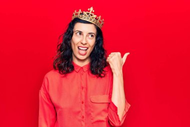 Prenses tacı takan genç ve güzel bir İspanyol kadın başparmağını yana uzatıyor ve mutlu bir şekilde gülümsüyor. 