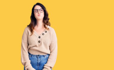 Güzel, genç, esmer, sıradan kıyafetler giyen, gözlüklü, komik yüzlü, yanakları şişen bir kadın. Havayla şişmiş ağız, çılgın bir ifade.. 