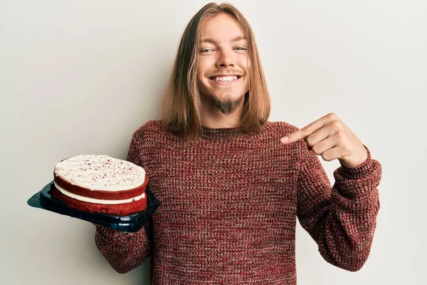 Knappe Blanke Man Met Lang Haar Met Worteltaart Wijzende Vinger — Stockfoto