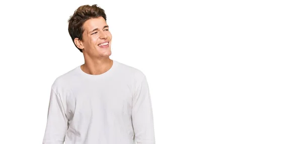 顔に笑顔で横に見えるカジュアルな白いセーターを着てハンサムな白人男性は 自然な表情 自信を持って — ストック写真