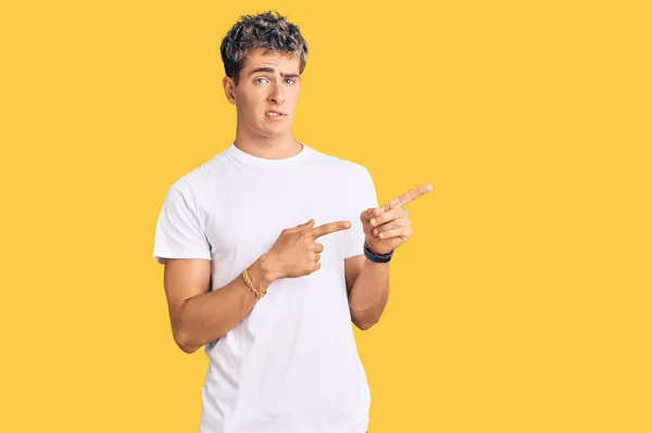 Mladý Pohledný Muž Neformální Bílé Košili Ukazuje Stranou Ustaraný Nervózní — Stock fotografie