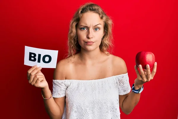 Gyönyörű Kaukázusi Kezében Vörös Alma Bio Szó Szkeptikus Ideges Homlokráncolás — Stock Fotó