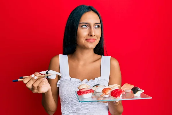 Jovem Morena Mulher Comer Butterfish Sushi Usando Pauzinhos Sorrindo Olhando — Fotografia de Stock