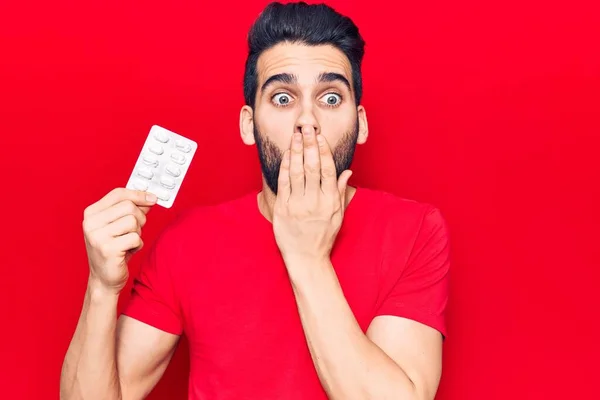 Joven Hombre Guapo Con Barba Sosteniendo Pastillas Cubriendo Boca Con —  Fotos de Stock