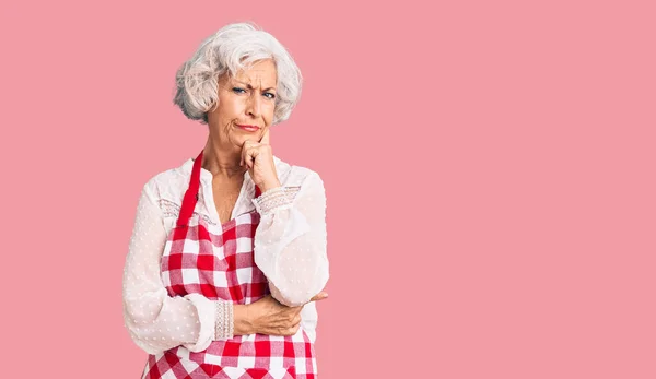 Ältere Grauhaarige Frau Mit Schürze Ernstes Gesicht Über Frage Nachdenkend — Stockfoto