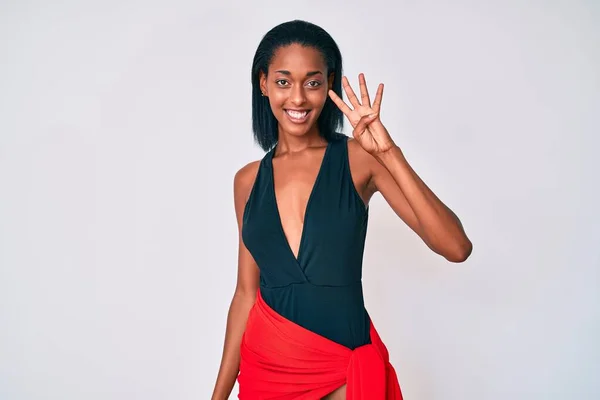 身穿泳衣的年轻的非洲裔美国女人 带着自信和快乐的笑容 用四号手指指指着 — 图库照片