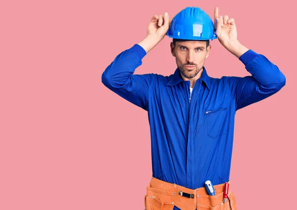 Jovem Homem Bonito Vestindo Uniforme Trabalhador Hardhat Fazendo Gesto Engraçado — Fotografia de Stock
