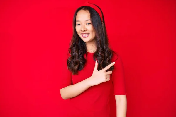 年轻美丽的中国姑娘穿着休闲装 笑容满面 手指手画脚地朝旁边走去 — 图库照片