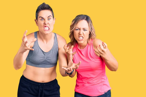 Couple Women Wearing Sportswear Shouting Frustrated Rage Hands Trying Strangle — Stock Photo, Image