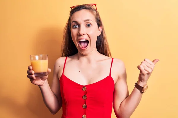 Junge Schöne Blonde Frau Trinkt Ein Glas Orangensaft Über Gelbem — Stockfoto