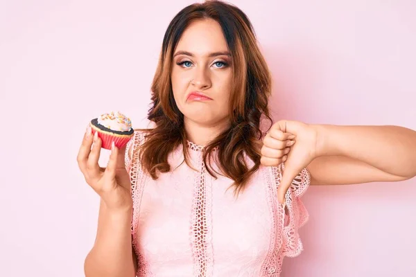 Νεαρή Όμορφη Καυκάσια Γυναίκα Κρατώντας Cupcake Θυμωμένο Πρόσωπο Αρνητική Ένδειξη — Φωτογραφία Αρχείου