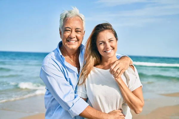 Latynoska Para Średnim Wieku Uśmiecha Się Szczęśliwa Przytula Spacerując Plaży — Zdjęcie stockowe