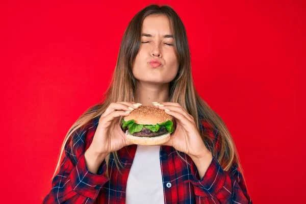 Belle Femme Caucasienne Mangeant Délicieux Hamburger Classique Regardant Caméra Souffler — Photo