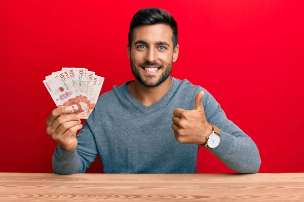 Hombre Hispano Guapo Sosteniendo Pesos Colombianos Sonriendo Feliz Positivo Pulgar — Foto de Stock