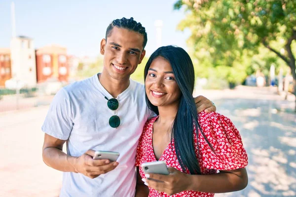Молода Латинська Пара Посміхається Щасливий Використовуючи Смартфон Вулиці Міста — стокове фото