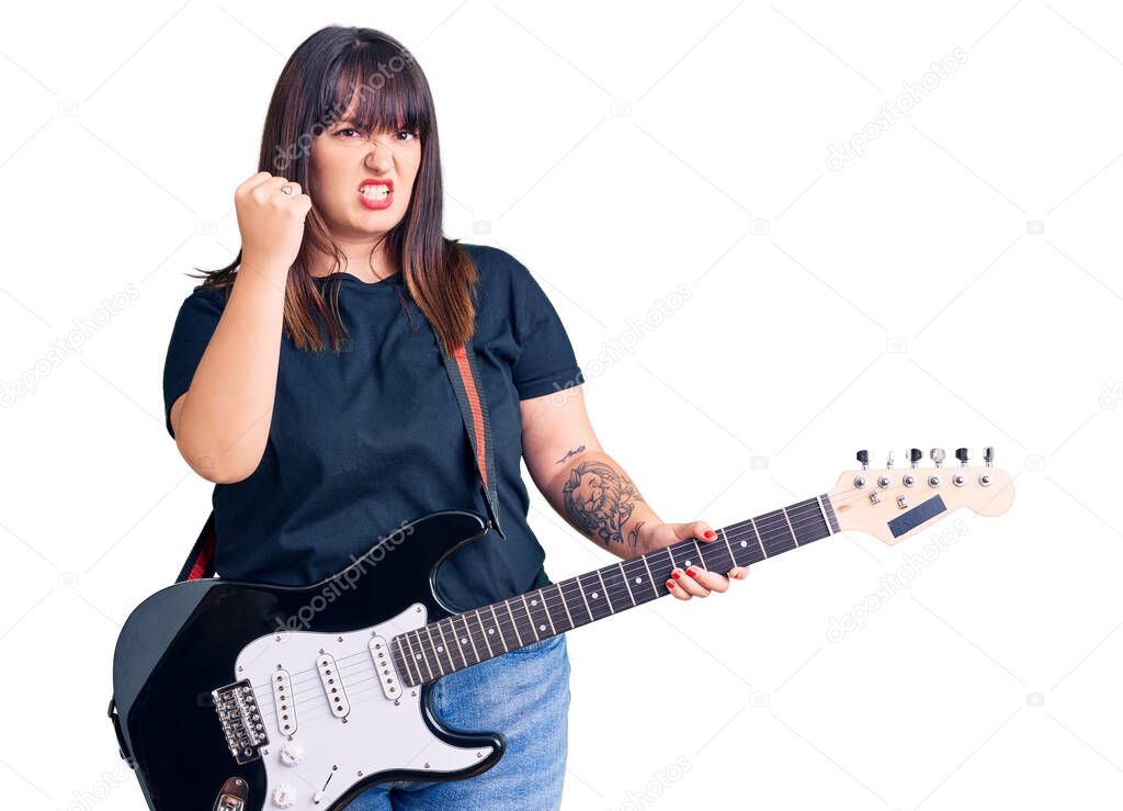 Young plus size woman playing electric guitar annoyed and frustrated shouting with anger, yelling crazy with anger and hand raised 